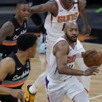 Phoenix Suns guard Jevon Carter (4) drives around San Antonio Spurs forward Keldon Johnson, left, during the first half of an NBA basketball game in San Antonio, Sunday, May 16, 2021. (AP Photo/Eric Gay)