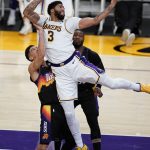 Los Angeles Lakers forward Anthony Davis (3) grabs a high pass over Phoenix Suns guard Devin Booker during the second half of an NBA basketball game Sunday, May 9, 2021, in Los Angeles. (AP Photo/Marcio Jose Sanchez)
