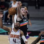 Phoenix Suns guard Jevon Carter (4) is blocked by San Antonio Spurs center Jakob Poeltl (25) as he tries to score during the first half of an NBA basketball game in San Antonio, Sunday, May 16, 2021. (AP Photo/Eric Gay)