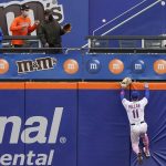 New York Mets center fielder Kevin Pillar climbs the outfield wall on a solo home run by Arizona Diamondbacks' Asdrubal Cabrera during the eighth inning of a baseball game, Sunday, May 9, 2021, in New York. (AP Photo/Kathy Willens)