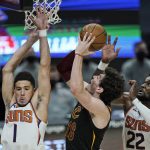 Phoenix Suns' Devin Booker (1) and Deandre Ayton (22) defend against Cleveland Cavaliers' Cedi Osman (16) in the second half of an NBA basketball game, Tuesday, May 4, 2021, in Cleveland. Phoenix won 134-118 in overtime. (AP Photo/Tony Dejak)