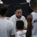 San Antonio Spurs assistant coach Mitch Johnson, center, talks to players during the first half of an NBA basketball game against the Phoenix Suns in San Antonio, Saturday, May 15, 2021. (AP Photo/Eric Gay)