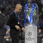 Manchester City's head coach Pep Guardiola walks past the trophy at the end of the Champions League final soccer match between Manchester City and Chelsea at the Dragao Stadium in Porto, Portugal, Saturday, May 29, 2021. Chelsea won the match 1-0. (Pierre Philippe Marcou/Pool via AP)
