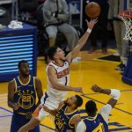 Phoenix Suns guard Devin Booker (1) shoots against Golden State Warriors forward Andrew Wiggins (22), guard Stephen Curry (30) and center Kevon Looney during the second half of an NBA basketball game in San Francisco, Tuesday, May 11, 2021. (AP Photo/Jeff Chiu)
