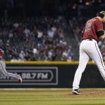 Arizona Diamondbacks relief pitcher Stefan Crichton, right, walks back to the mound after giving up a home run to Washington Nationals' Yadiel Hernandez, left, during the eighth inning of a baseball game Sunday, May 16, 2021, in Phoenix. (AP Photo/Ross D. Franklin)