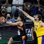 
              Phoenix Suns guard Devin Booker, left, gets past Los Angeles Lakers center Marc Gasol (14) to score during the first half of Game 2 of their NBA basketball first-round playoff series Tuesday, May 25, 2021, in Phoenix. (AP Photo/Ross D. Franklin)
            