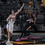 San Antonio Spurs guard Dejounte Murray (5) shoots over Phoenix Suns forward Dario Saric (20) during the first half of an NBA basketball game in San Antonio, Sunday, May 16, 2021. (AP Photo/Eric Gay)