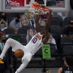 Phoenix Suns forward Jalen Smith (10) hangs on the rim as he scores against the Phoenix Suns during the second half of an NBA basketball game in San Antonio, Sunday, May 16, 2021. (AP Photo/Eric Gay)