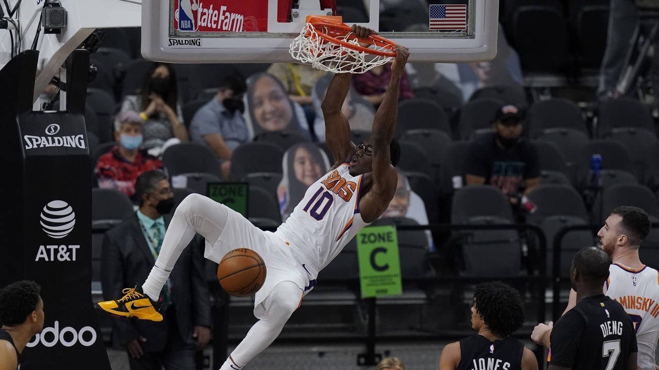 Phoenix Suns forward Jalen Smith (10) hangs on the rim as he scores against the Phoenix Suns during...