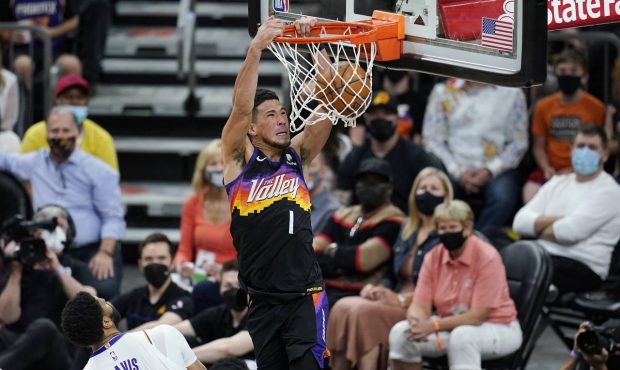 Phoenix Suns guard Devin Booker (1) dunks as he drives past Los Angeles Lakers forward Anthony Davi...