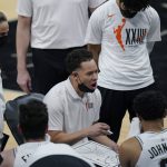 San Antonio Spurs assistant coach Mitch Johnson, center, talks to players during the first half of an NBA basketball game against the Phoenix Suns in San Antonio, Saturday, May 15, 2021. (AP Photo/Eric Gay)
