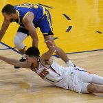 Golden State Warriors guard Stephen Curry, top, reaches for the ball over Phoenix Suns guard Devin Booker during the second half of an NBA basketball game in San Francisco, Tuesday, May 11, 2021. (AP Photo/Jeff Chiu)