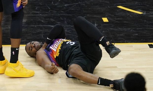 An injured Phoenix Suns guard Chris Paul grabs his shoulder during the first half of Game 1 of thei...