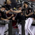 Arizona Diamondbacks position player Wyatt Mathisen, right, greets his teammates after pitching in relief during the ninth inning of a baseball game against the Colorado Rockies, Saturday, May 1, 2021, in Phoenix. (AP Photo/Matt York)