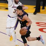 Phoenix Suns guard Devin Booker, right, is guarded by Los Angeles Lakers forward Anthony Davis during the first half of an NBA basketball game Sunday, May 9, 2021, in Los Angeles. (AP Photo/Marcio Jose Sanchez)