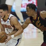 Phoenix Suns' Devin Booker, left, drives past Cleveland Cavaliers' Isaac Okoro in the first half of an NBA basketball game, Tuesday, May 4, 2021, in Cleveland. (AP Photo/Tony Dejak)
