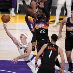 Los Angeles Lakers guard Alex Caruso (4) drives past Phoenix Suns center Deandre Ayton (22) and guard Devin Booker (1) during the second half of an NBA basketball game Sunday, May 9, 2021, in Los Angeles. (AP Photo/Marcio Jose Sanchez)