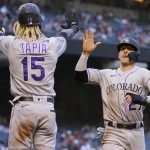 
              Colorado Rockies' Trevor Story (27) and Raimel Tapia (15) high five after scoring on a base hit by Ryan McMahon during the fourth inning of a baseball game against the Arizona Diamondbacks, Saturday, May 1, 2021, in Phoenix. (AP Photo/Matt York)
            