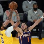 Los Angeles Lakers forward Anthony Davis (3) shoots over Phoenix Suns guard Devin Booker (1) during the first half in Game 3 of an NBA basketball first-round playoff series Thursday, May 27, 2021, in Los Angeles. (AP Photo/Marcio Jose Sanchez)