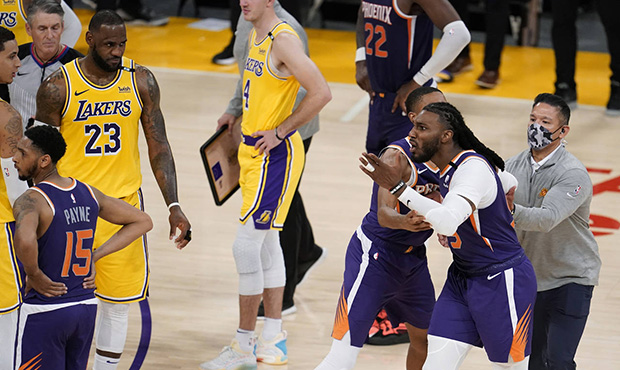 Phoenix Suns forward Jae Crowder, second from right, is held back after being ejected during the se...