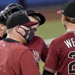 Arizona Diamondbacks pitching coach Matt Herges, left, talks with starting pitcher Luke Weaver (24) and third baseman Eduardo Escobar (5) during the first inning of a baseball game against the Miami Marlins, Wednesday, May 5, 2021, in Miami. (AP Photo/Lynne Sladky)