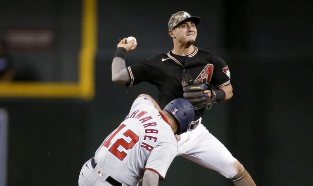 Washington Nationals' Kyle Schwarber slides after being forced out by Arizona Diamondbacks' Josh Ro...