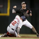 Washington Nationals' Kyle Schwarber slides after being forced out by Arizona Diamondbacks' Josh Rojas during the seventh inning of a baseball game Friday, May 14, 2021, in Phoenix. Josh Bell was safe at first. (AP Photo/Darryl Webb)