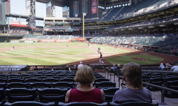 Socially distanced fans at Chase Field watch the Arizona Diamondbacks and the Cleveland Indians dur...