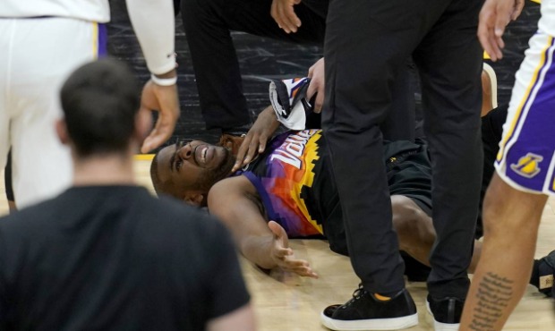 An injured Phoenix Suns guard Chris Paul grimaces in pain during the first half of Game 1 of their ...