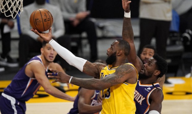 Los Angeles Lakers forward LeBron James, left, shoots as Phoenix Suns center Deandre Ayton defends ...