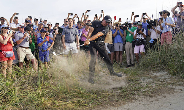 Fans cheer after Phil Mickelson hit his second shot on the 16th hole from the rough during the thir...