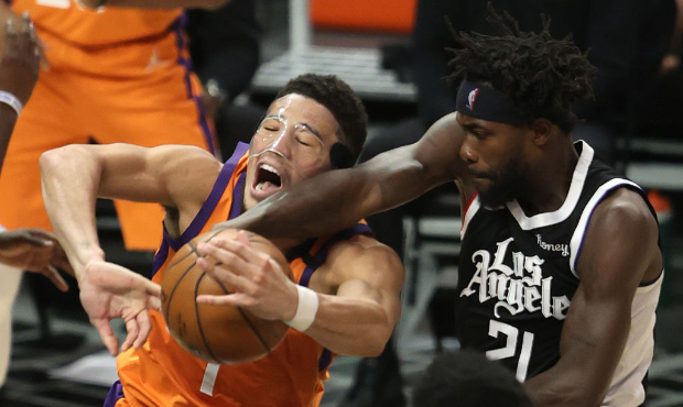 Patrick Beverley #21 of the LA Clippers knocks the ball from the hands of Devin Booker #1 of the Ph...