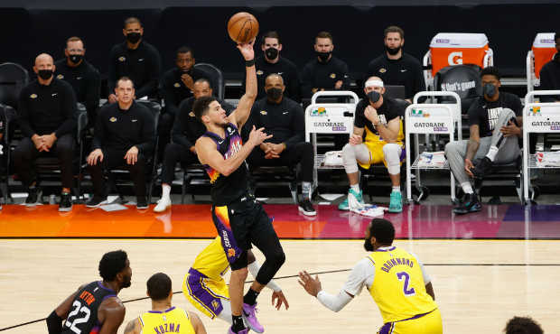 Devin Booker #1 of the Phoenix Suns puts up a shot over Andre Drummond #2 of the Los Angeles Lakers...