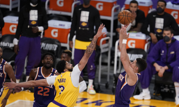 Phoenix Suns guard Devin Booker (right) shoots over Los Angeles Lakers forward Anthony Davis (left)...