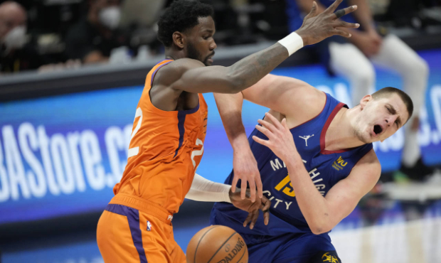 Denver Nuggets center Nikola Jokic, right, loses control of the ball as Phoenix Suns center Deandre...