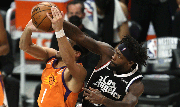 Patrick Beverley of the LA Clippers knocks the ball from the hands of Devin Booker of the Phoenix S...