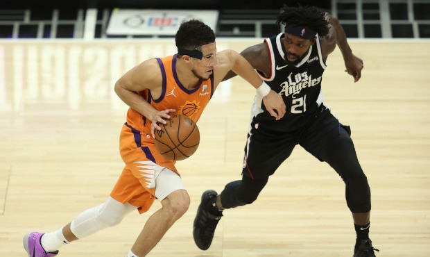 Devin Booker #1 of the Phoenix Suns drives against Patrick Beverley #21 of the LA Clippers during t...