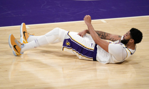 Anthony Davis #3 of the Los Angeles Lakers grabs his thigh after falling during the first half of G...