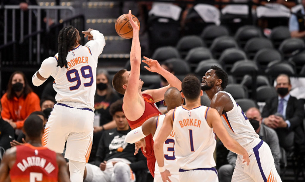 Jae Crowder #99 of the Phoenix Suns blocks a shot attempt by Nikola Jokic #15 of the Denver Nuggets...