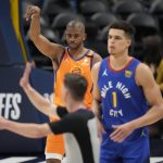 Phoenix Suns guard Chris Paul, back, reacts after hitting a basket, next to Denver Nuggets forward Michael Porter Jr., center, and referee Ben Taylor during the second half of Game 3 of an NBA second-round playoff series Friday, June 11, 2021, in Denver. Phoenix won 116-102. (AP Photo/David Zalubowski)