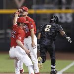 Arizona's TJ Nichols, left, drops the ball as Vanderbilt's Javier Vaz (2) reaches first base during the 11th inning of a baseball game in the NCAA College World Series on Saturday, June 19, 2021, in Omaha, Neb. (AP Photo/Rebecca S. Gratz)