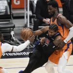 Los Angeles Clippers' Paul George, center, is defended by Phoenix Suns' Jae Crowder, left, and Deandre Ayton during the first half in Game 6 of the NBA basketball Western Conference Finals Saturday, June 26, 2021, in Los Angeles. (AP Photo/Jae C. Hong)