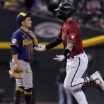 Arizona Diamondbacks' Christian Walker rounds the bases after hitting a solo home run as Milwaukee Brewers' Luis Urias, left, looks on during the seventh inning of a baseball game, Wednesday, June 23, 2021, in Phoenix. (AP Photo/Matt York)
