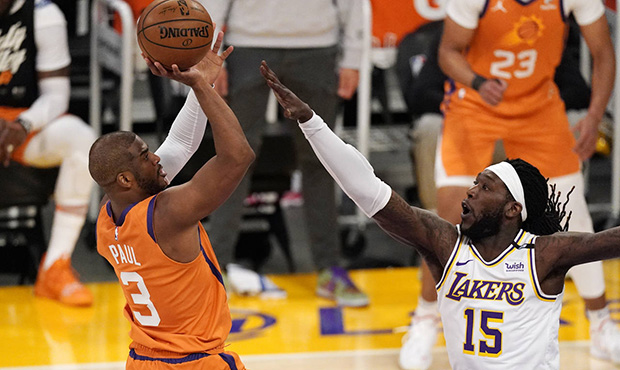 Phoenix Suns guard Chris Paul, left, shoots as Los Angeles Lakers center Montrezl Harrell defends d...