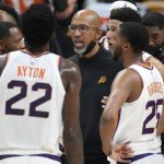 Phoenix Suns head coach Monty Williams, center, confers with players during a timeout late in the second half of Game 4 of an NBA second-round playoff series against the Denver Nuggets, Sunday, June 13, 2021, in Denver. Phoenix won 125-118 to sweep the series. (AP Photo/David Zalubowski)
