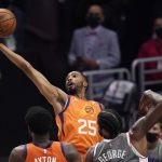 Phoenix Suns forward Mikal Bridges, left, grabs a rebound away from Los Angeles Clippers guard Paul George, right, during the first half in Game 4 of the NBA basketball Western Conference Finals Saturday, June 26, 2021, in Los Angeles. (AP Photo/Mark J. Terrill)