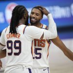 Phoenix Suns forward Jae Crowder, left, hugs forward Mikal Bridges as time runs out in the second half of Game 4 of an NBA second-round playoff series against the Denver Nuggets, Sunday, June 13, 2021, in Denver. Phoenix won 125-118 to sweep the series. (AP Photo/David Zalubowski)