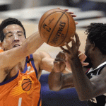 Phoenix Suns guard Devin Booker, left, blocks a pass intended for Los Angeles Clippers guard Patrick Beverley during the first half in Game 3 of the NBA basketball Western Conference Finals Thursday, June 24, 2021, in Los Angeles. (AP Photo/Mark J. Terrill)