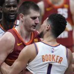 Denver Nuggets center Nikola Jokic, left, squares off with Phoenix Suns guard Devin Booker in the second half of Game 4 of an NBA second-round playoff series, Sunday, June 13, 2021, in Denver. (AP Photo/David Zalubowski)
