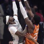 Los Angeles Clippers guard Reggie Jackson, left, shoots as Phoenix Suns center Deandre Ayton defends during the first half in Game 4 of the NBA basketball Western Conference Finals Saturday, June 26, 2021, in Los Angeles. (AP Photo/Mark J. Terrill)